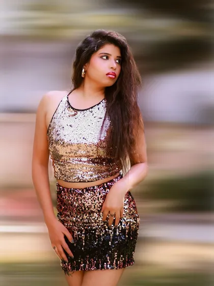 A vibrant and energetic portrait with a motion blur background. The gold sequin outfit shines, creating a glamorous and eye-catching look.