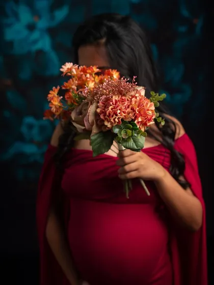 A creative and modest portrait, where the mother-to-be holds a bouquet of flowers, symbolizing the new life she is nurturing.