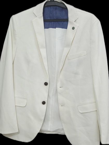 A versatile and classic off-white blazer for rent. This piece can be dressed up or down, making it perfect for a casual pre-wedding shoot or a semi-formal event.