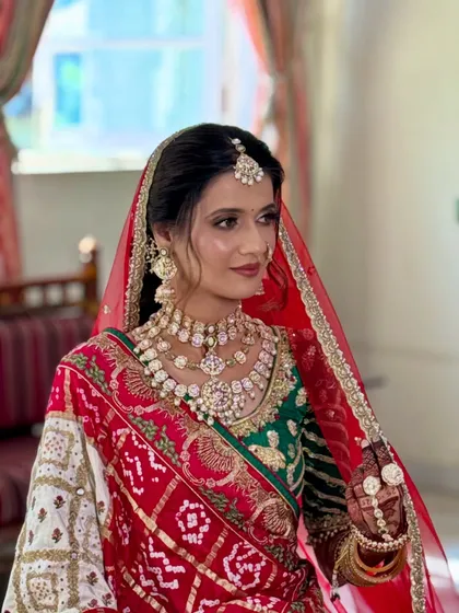 This bride's look is a beautiful blend of tradition and elegance. The makeup features a flawless base and soft contouring to enhance her features.