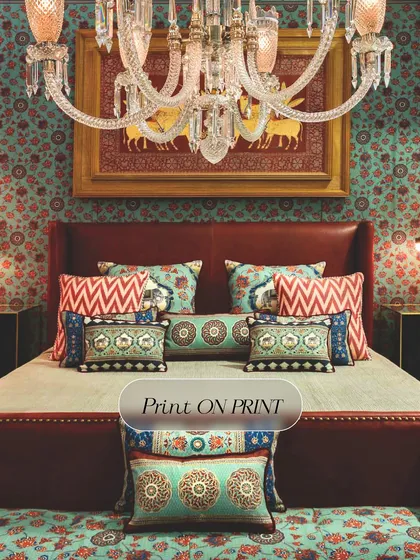 I believe in celebrating the art of 'more'. This bedroom showcases a maximalist approach, layering print on print with a bold, floral wallpaper that envelops the room in color and personality, creating a space that is vibrant and full of life.