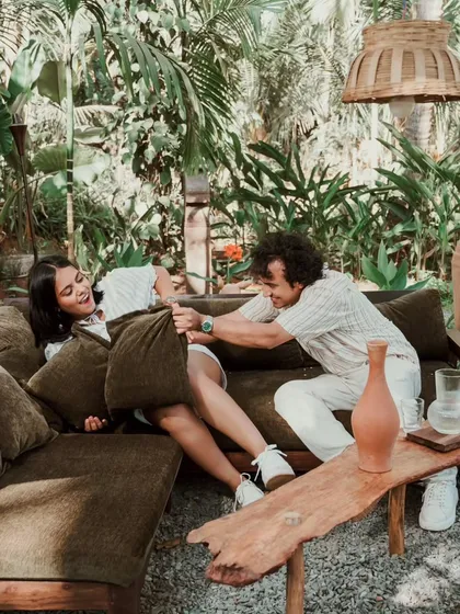 A playful pillow fight on a couch set in a lush Goan garden. This candid couple photograph shows the fun and lighthearted side of love that we love to document.
