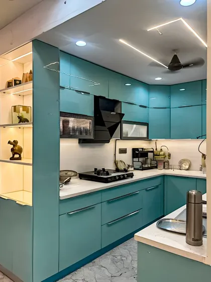 This compact L-shaped kitchen showcases how a bold color choice can create a vibrant and modern space. The teal blue cabinets are paired with a clean white countertop and backsplash. We integrated profile lighting under the upper cabinets and recessed ceiling lights to ensure the kitchen is bright and functional.