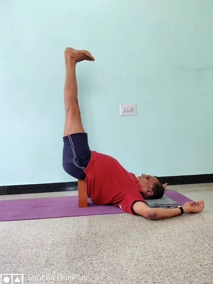 This is Viparita Karani, or Legs-Up-the-Wall Pose, supported by a brick. We end every session with restorative postures like this to help the body absorb the effects of the practice and calm the nervous system.