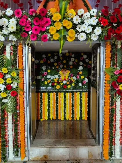 A closer look inside a pandal, where we decorated the inner sanctum. The entrance to the idol is framed with colorful gerbera daisies and marigold garlands, creating a beautiful focal point.