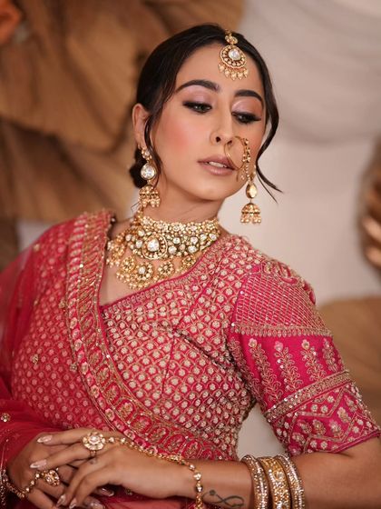 A complete bridal look featuring a heavy, gold-plated Kundan necklace, haath phool, and maang tikka, all available for rent.