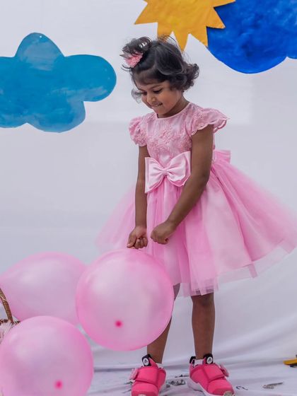 A vision in pink. This party dress features a full tulle skirt and a beautifully detailed bodice, perfect for making a grand entrance at any celebration.