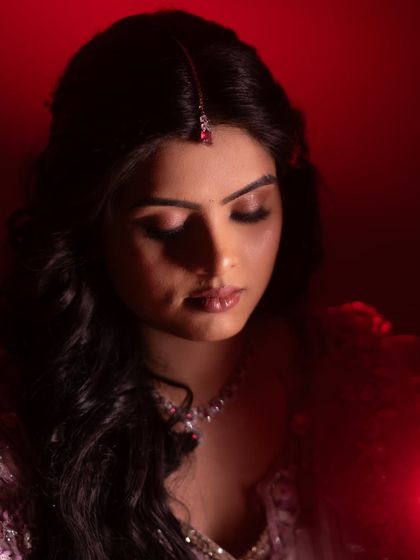 A dramatic portrait of the bride-to-be, bathed in red light. This shot highlights her striking features and the emotion of the moment.