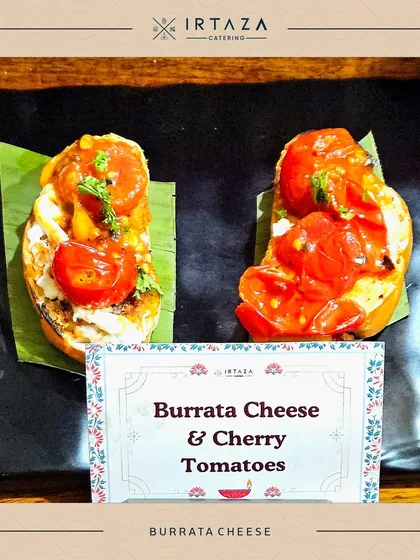 Burrata Cheese and Cherry Tomato Bruschetta. The creamy burrata and sweet, juicy tomatoes on toasted bread create a simple yet incredibly flavorful appetizer, served here on a banana leaf for a rustic touch.