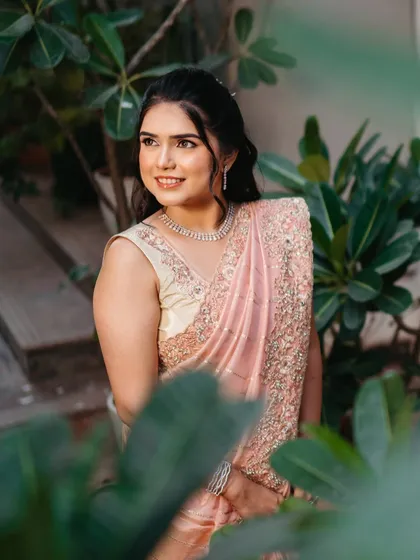 A beautiful portrait of the bride. The soft lighting and natural background highlight her glowing skin and the delicate embroidery on her saree.