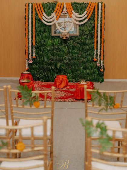 A simple yet profound backdrop for a pre-wedding ritual, created entirely from fresh coffee leaves sourced from the bride's family estate in Coorg. Garlands of marigold and tuberose add a traditional touch.