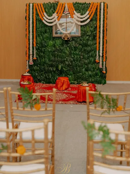 A simple yet profound backdrop for a pre-wedding ritual, created entirely from fresh coffee leaves sourced from the bride's family estate in Coorg. Garlands of marigold and tuberose add a traditional touch.