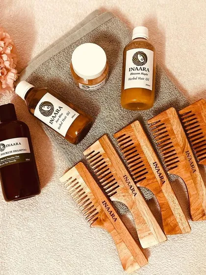 A beautiful flat-lay of my complete herbal hair care family. You can see my All Nourish Shampoo, hair oils, hair mask powder, and Neem combs, all designed to work in harmony.