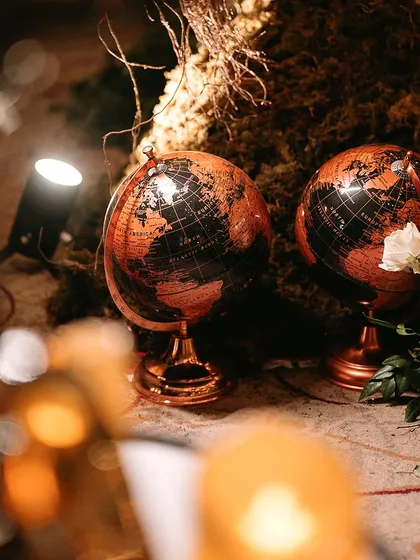 A pair of globes used as decor elements, symbolizing a world of love and adventure for the couple.