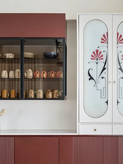 This custom crockery unit from the "Crimson Paradise" project is a work of art. The deep red cabinets are paired with a white unit featuring frosted glass doors with a beautiful, custom art deco-inspired motif.