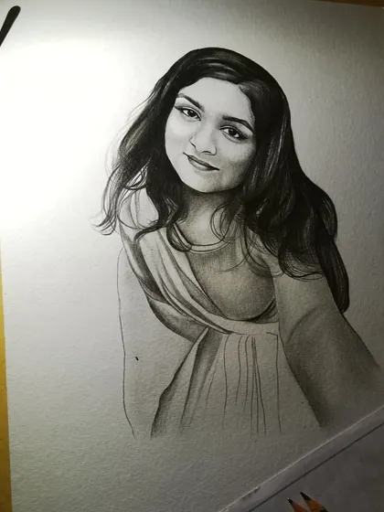 Another angle of the work-in-progress sketch. The lighting in this shot highlights the texture of the paper and the pencil strokes.