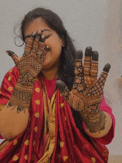 A playful peek-a-boo pose with hands full of beautiful, intricate henna.