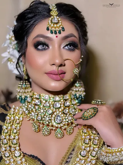 A stunning close-up focusing on the intricate details of the kundan jewelry and the flawless makeup.