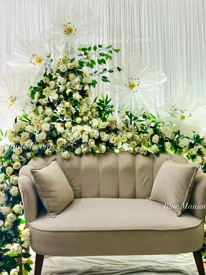 A straight-on view of the artistic floral couch setup. The design is balanced and grand, perfect for making a statement at a Roka or engagement party.