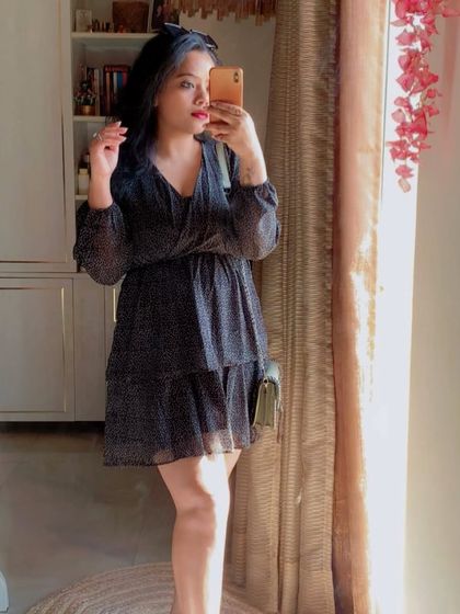 Another mirror selfie of the polka-dot black dress, showing its flattering silhouette.