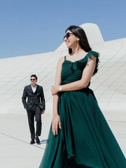 A fashionable, dynamic shot at the Heydar Aliyev Centre in Baku. The contrast between her flowing green dress and the stark white architecture creates a visually stunning image. It’s a perfect blend of high fashion and romance.