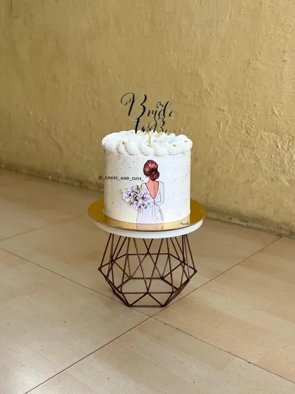 An elegant "Bride to be" cake featuring a beautiful illustration of a bride holding a bouquet. Perfect for a bachelorette party or bridal shower.