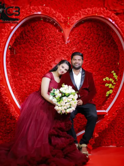 A romantic pre-wedding portrait using my heart-themed studio backdrop. I provide coordinated outfits, like this couple's maroon gown and velvet blazer, to create a perfectly styled shot.