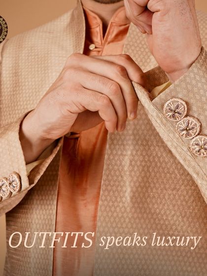 Outfits that speak luxury. A detailed shot of a beige jacket sleeve, showing the custom buttons and fine fabric.