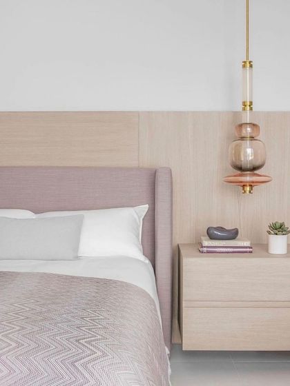 A single, vertically oriented Luna pendant serves as an elegant bedside light. This application shows the versatility of the collection, proving that even a single element can provide a touch of glamour and sophisticated design to an intimate space.