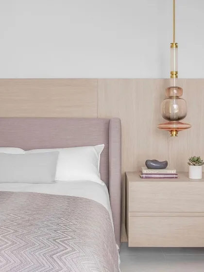 The Luna Kaleido pendant used as a bedside light. Its soft glow and beautiful stacked glass form make it a perfect piece of jewelry for a serene and luxurious bedroom.