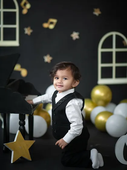 A happy smile from our little pianist. The black, white, and gold color scheme creates a sophisticated yet fun look for a first birthday.