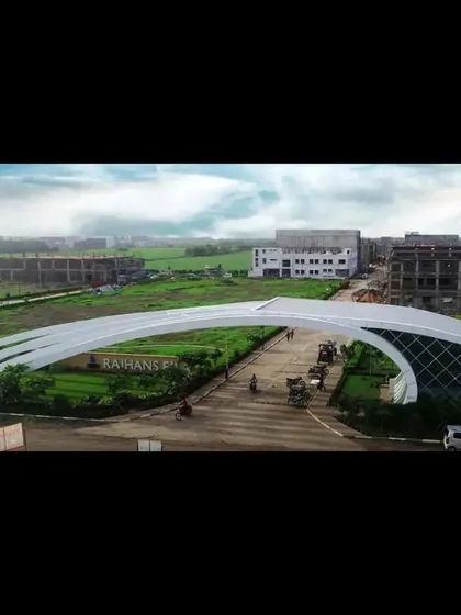 An aerial view of the entrance gate, showing its scale relative to the surrounding landscape and infrastructure. This perspective reveals the full arc of the architectural structure.