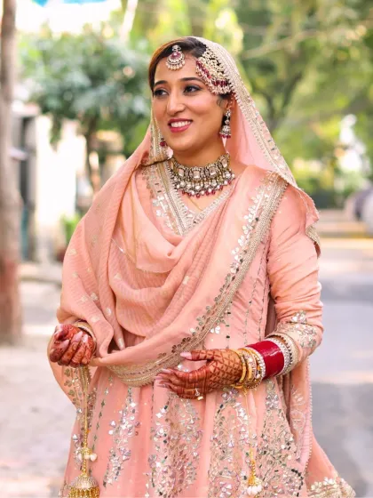 A candid moment of the bride. Her makeup is soft and radiant, designed to look beautiful in natural light and capture her happy emotions.