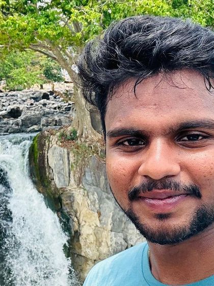 A close-up shot with the beautiful Hogenakkal waterfalls in the background.
