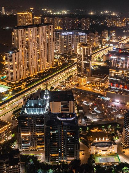 A long-exposure aerial photograph of Gurgaon's Golf Course Road during Diwali, with light trails from traffic creating a vibrant, festive cityscape.