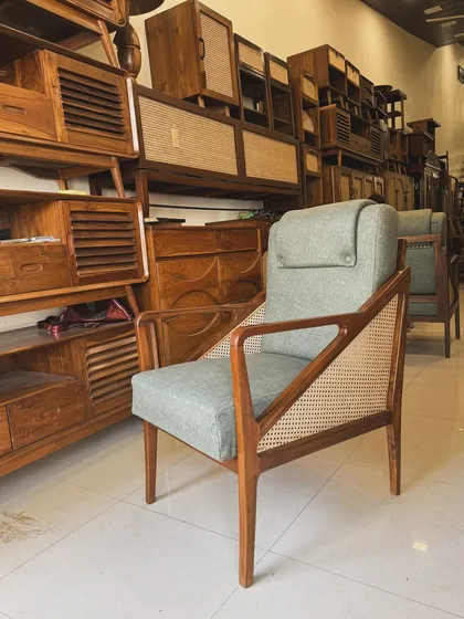 A comfortable lounge chair with a high back, adjustable headrest, and cane side panels, displayed in my showroom.