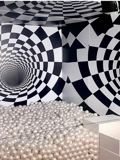 An interactive ball pit combined with a dizzying optical illusion backdrop creates a fun and disorienting photo experience. This type of custom illusion booth is perfect for brand activations that want to stand out.