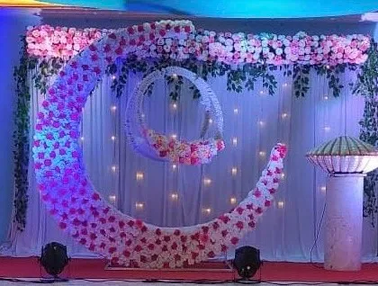 A closer look at the floral moon and cradle setup for a naming ceremony. The twinkling lights in the backdrop and the soft blue and pink lighting create a magical ambiance for the event.