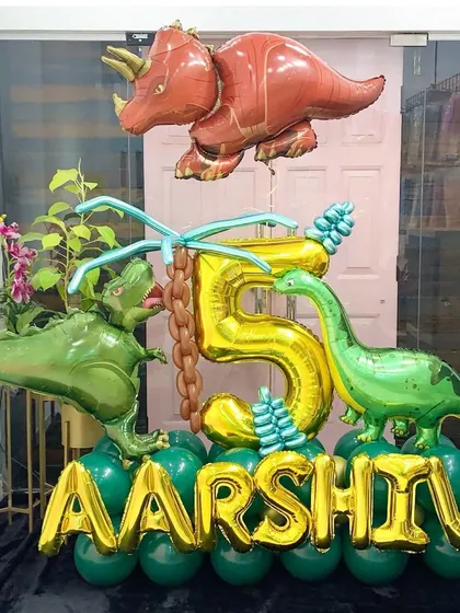A rawr-some dinosaur name and age display for Aarshiv's 5th birthday. This arrangement uses large foil dinosaur balloons combined with a golden number and name to create a big impact in a smaller space.