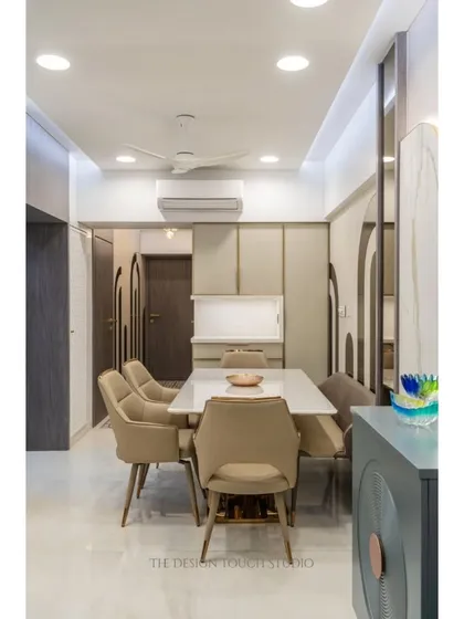 This angle shows the dining setup in relation to the rest of the open-plan living space. The consistent use of neutral tones and clean lines creates a harmonious and inviting atmosphere.