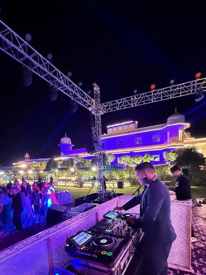 An outdoor sangeet against the stunning backdrop of a Jaipur palace. My setup integrates seamlessly with grand decor, providing the perfect sound and light experience for a royal celebration.