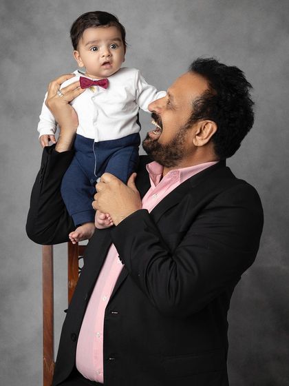 A grandfather's joy is infectious in this playful portrait with his grandbaby. These candid moments of laughter are truly precious.