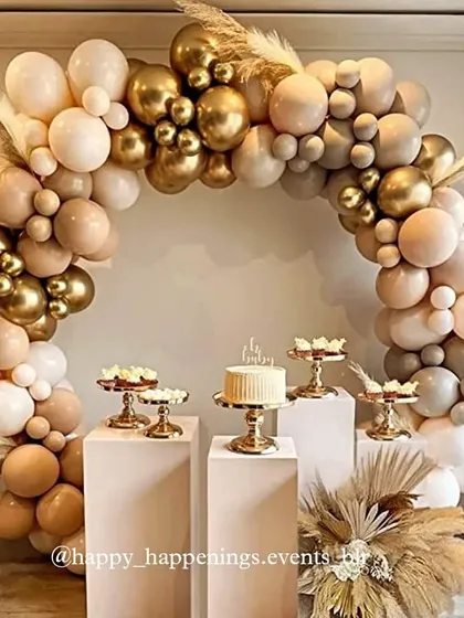 This chic and neutral-toned boho setup shows our love for sophisticated palettes. A flowing balloon arch in beige, brown, and gold creates a warm and inviting space for the dessert display, complete with pampas grass for that perfect rustic touch.