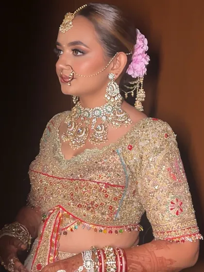 A bride with a sophisticated low bun, decorated with pink hydrangeas and intricate hair jewellery. This hairstyle is a perfect blend of floral beauty and traditional ornamentation.
