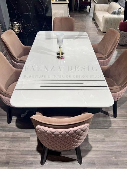 A closer look at the white onyx dining table, featuring subtle black inlay details for a modern, graphic touch. The chairs' quilted backrests add a layer of texture and comfort.
