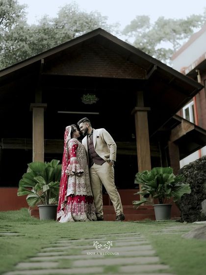 The couple sharing a moment before a rustic wooden building, a grand and romantic pose.