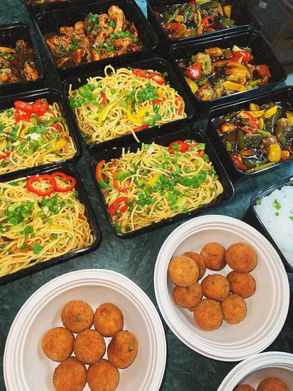 An Asian feast packed for a house party. This delivery included our vegetable hakka noodles, chili chicken, and crispy arancini balls.
