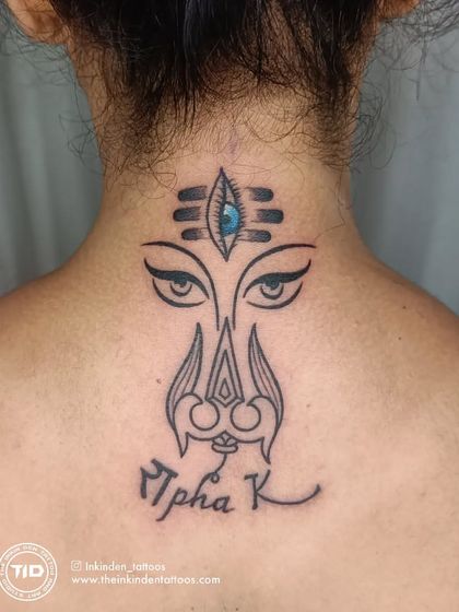 This custom neck tattoo merges the powerful eyes of the Goddess, the Trishul, and the third eye. It's a symbol of divine feminine power, protection, and insight, personalized with the client's name.