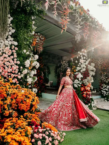 A breathtaking shot of my bride Punya at her engagement. The vibrant red lehenga and the grand floral decor are perfectly matched by a radiant and classic makeup look, creating a truly unforgettable bridal portrait.