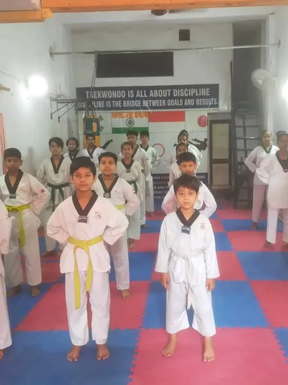 A group of students in formation, ready to begin their belt promotion test. Discipline and order are fundamental to our classes.